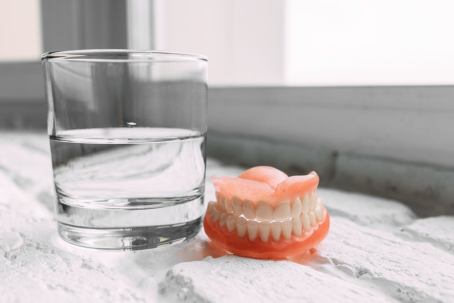 A Denture In A Glass Of Water. Dental Prosthesis Care. Full Remo